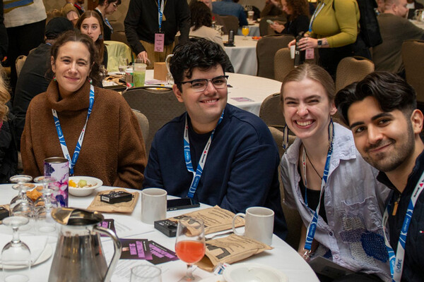 Shayan sitting with other attendees at the Community-Based Research Summit in Vancouver
