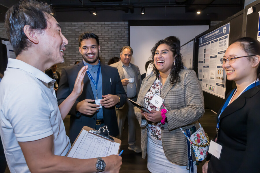 Dr. Mike Ohh talking with Kim Crasta, Sai-Amrit Maharaj & Ellis Gao at the LMPRC 2023