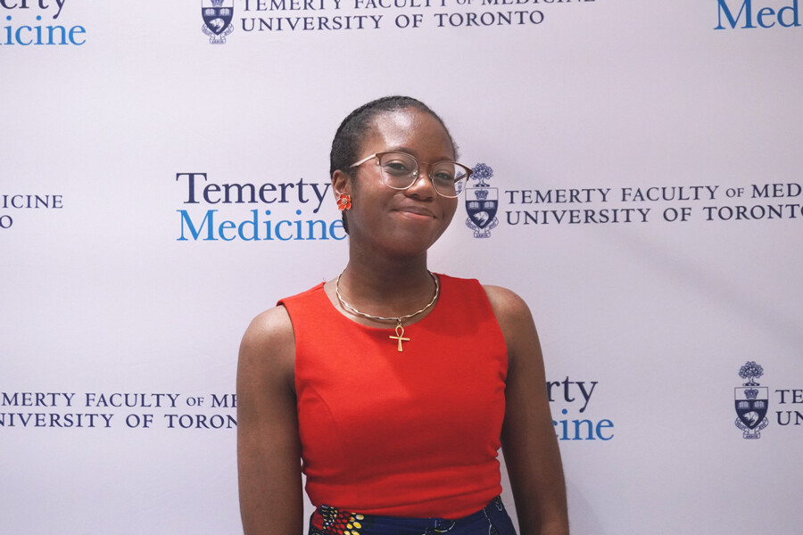 Tala Lumbu standing against a Temerty Medicine step and repeat background